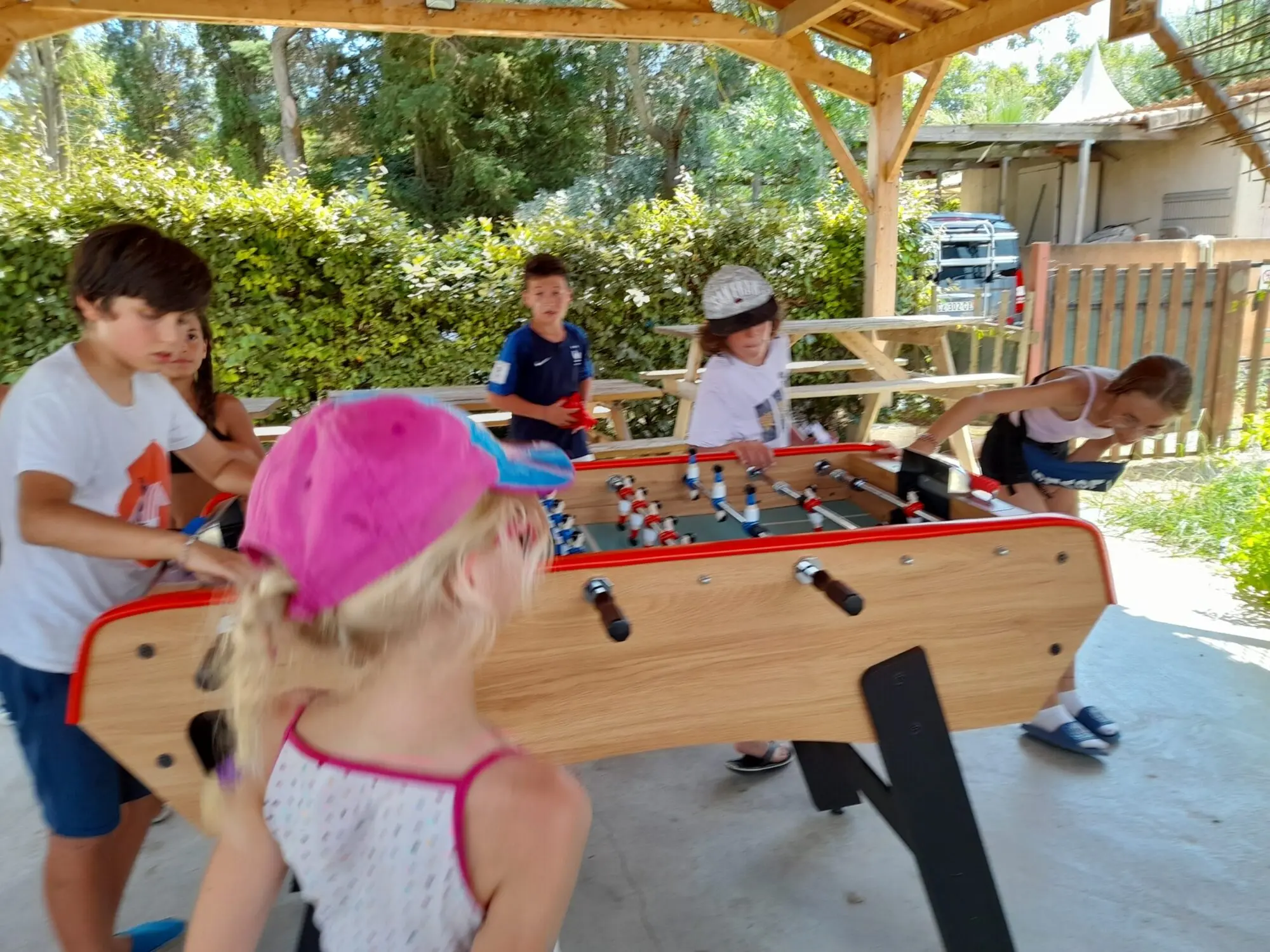 Enfants qui jouent au baby-foot sous notre préau